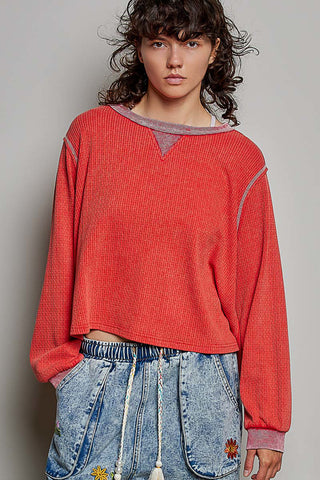 A cherry red waffle knit oversized long sleeve shirt with a crew neckline and long sleeves.