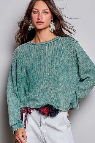 Woman wearing an oversized waffle knit long sleeve shirt in evergreen.