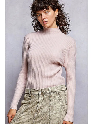 A fitted mock neck sweater in pale pink with rib-knit texture, worn by a model.