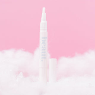 A whitening gel pen with the brand 'beaut.' in a soft pink setting.
