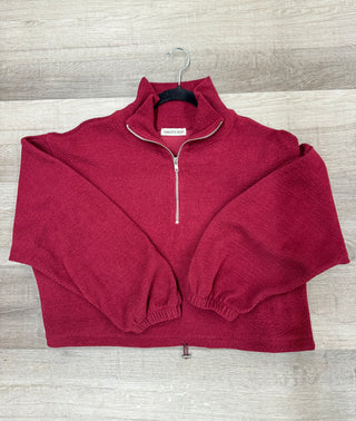 Burgundy ribbed knit pullover with oversized fit and half zip detail.