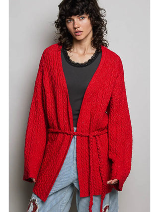 Ruby red sweater cardigan with an adjustable drawstring, worn by a model over a black top.