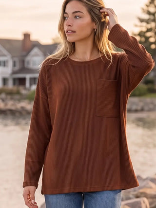 Rust-colored curly ribbed crew neck top with long sleeves and a relaxed fit.