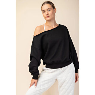 A woman wearing a black off-shoulder top made of French terry fleece.