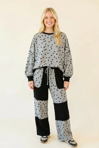Floral patchwork lounge pants in black with waffle knit texture and relaxed fit, shown on a model.