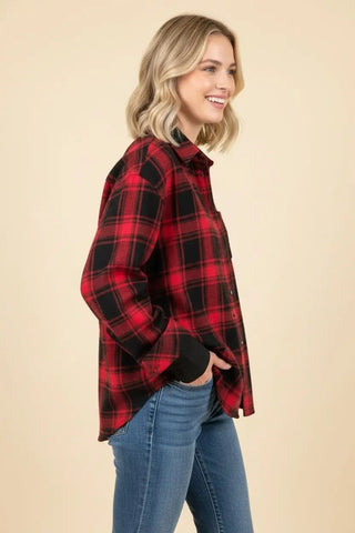 A woman wearing a red plaid button-down flannel shirt with long sleeves.