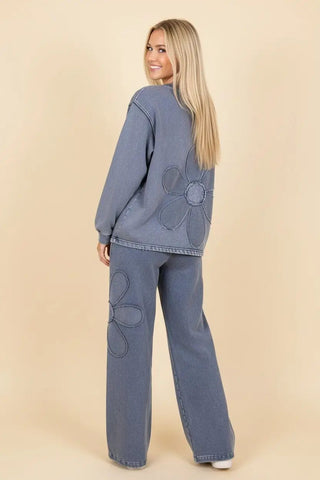 Model wearing denim wide leg pants with drawstring waist and floral embroidery on the back.