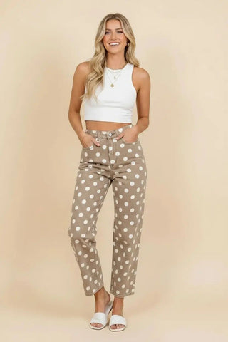 Woman wearing taupe polka dot high rise straight leg pants with a white crop top and sandals.