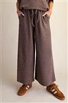 Wide-leg mocha pants with an elastic waist and drawstring, shown with hands in pockets.