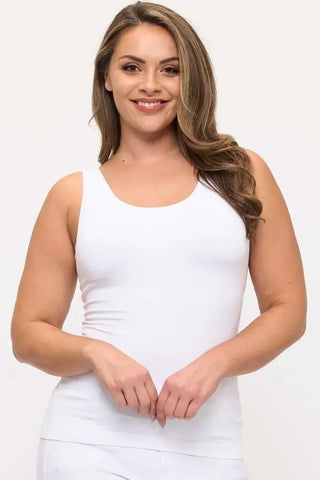 A woman wearing a white seamless tank top with a built-in bra.