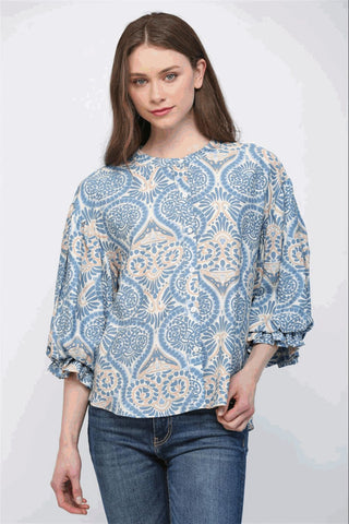 A blue multi-color blouse with a damask print, featuring voluminous balloon sleeves and a button-down front.