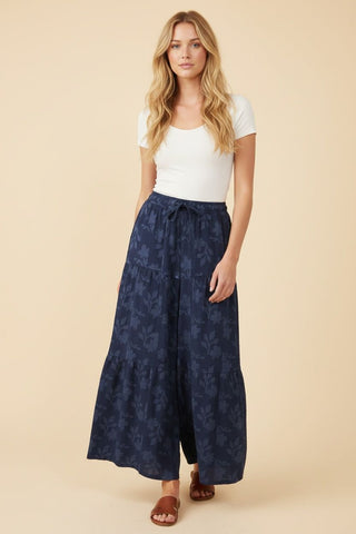 Wide leg navy lounge pants with a floral pattern worn by a model in a white top.