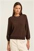 Model wearing a brown long sleeve top with a relaxed fit.