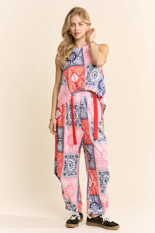 A woman wearing a red and navy bandana patchwork tank and pants set.