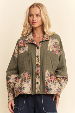 A woman wearing a Davi & Dani floral tapestry patchwork shirt with a button-front and peplum silhouette in floral jacquard.