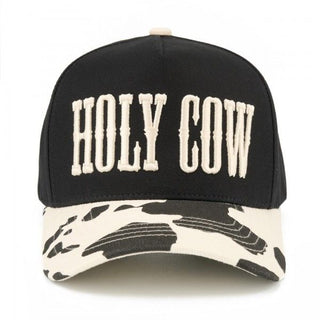 Two tone baseball cap with 'HOLY COW' embroidered on the front and a cow print brim.