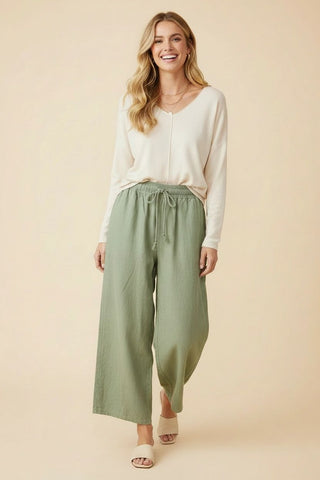 Sage high-rise wide-leg pants with a drawstring waist and pockets.