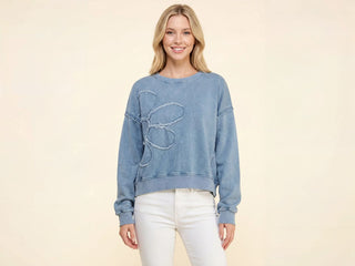 A denim oversized sweatshirt with a large flower patch design on the front.