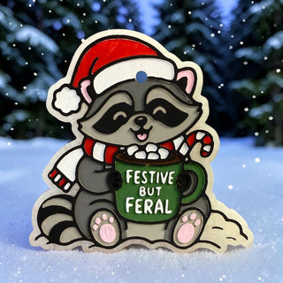 Festive raccoon Freshie holding a mug with 'Festive But Feral' text, wearing a Santa hat and scarf.