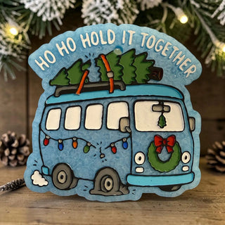 Holiday-themed freshie with a blue bus carrying Christmas trees and the phrase 'Ho Ho Hold It Together'.