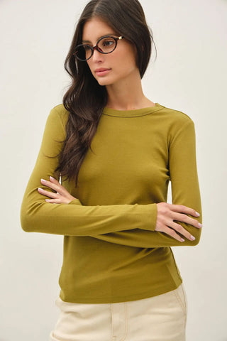 A moss-colored long sleeve knit top with a round neckline worn by a person with glasses.