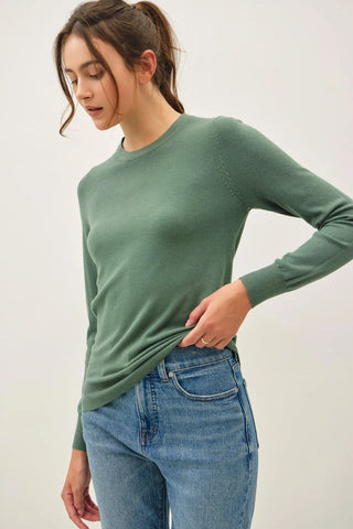 Hunter green knit sweater with a crew neck, worn by a model with jeans.