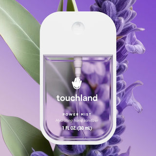 Touchland Lavender Power Mist Hydrating Hand Sanitizer in a compact, clear container with lavender flowers in the background.