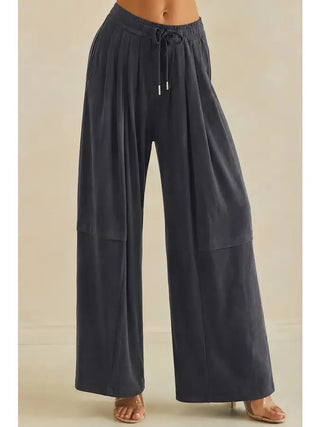 Wide-leg flowy pants in charcoal with an elastic waistband and drawstring.