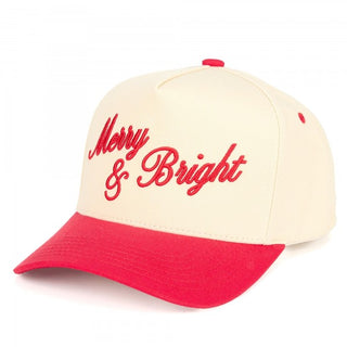 A two-tone baseball cap in cream with 'Merry & Bright' embroidered in red and a red brim.