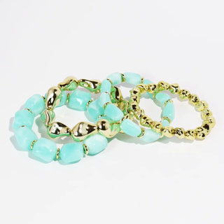 A set of beaded bracelets featuring mint stones and gold accents.