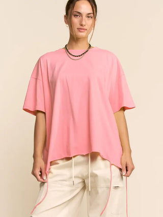 A model wearing a pink oversized tee with a drawstring hem.