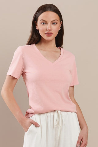 Peach-colored cotton T-shirt with a V-neckline and short sleeves worn by a model.