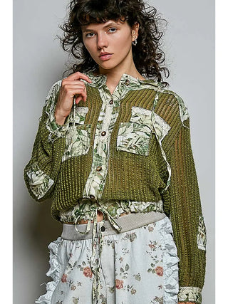 A woman wearing a vintage washed floral patch jacket in olive and cream multi-color with crochet details.