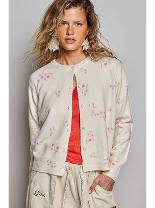 A cream cardigan with an allover floral print and button front.
