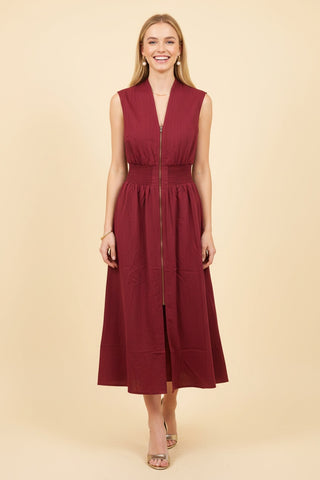 Sleeveless midi dress in rich burgundy with a front zip closure, worn by a smiling model.
