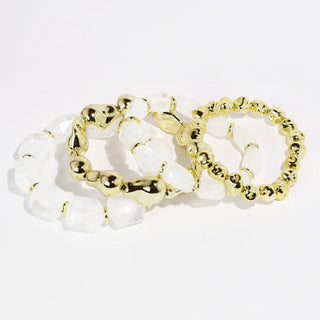 Set of clear and gold-tone beaded bracelets arranged together.