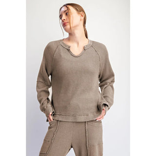A woman wearing a coffee-colored, mineral washed waffle raglan long sleeve top.