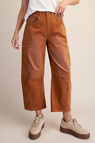 Camel-colored corduroy barrel pants with a relaxed fit, worn with a white top and sneakers.
