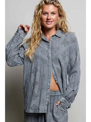 A charcoal button-front shirt with embroidered motifs and eyelet cutwork, worn by a model.