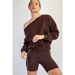Woman wearing an espresso-colored off-shoulder top and shorts.