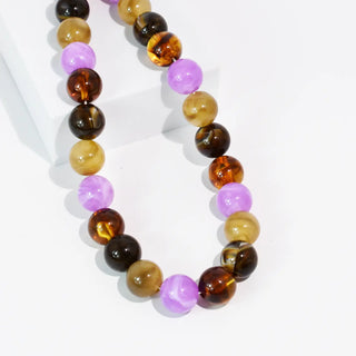 Necklace with alternating round beads in shades of purple and amber.