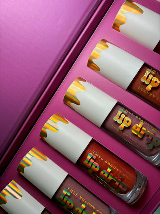 A set of multicolor lip products with gradient packaging in a pink box.