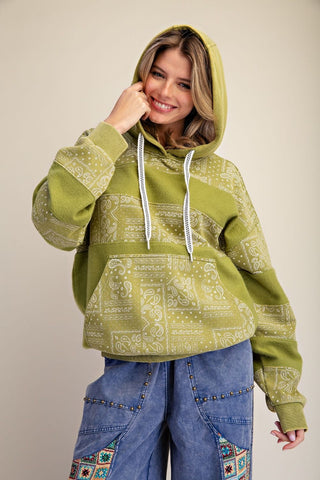 Model wearing a matcha-colored bandana printed hooded pullover.