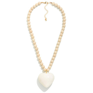 Necklace with stone beads and a white acrylic heart pendant.
