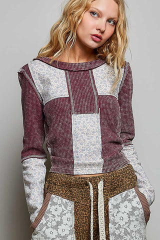 Waffle knit top in blood red with contrast patchwork design and long sleeves.