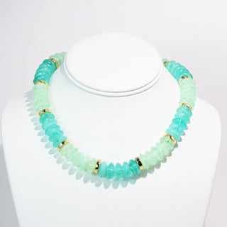 A necklace with multi-color beads in shades of blue and green, accented with gold-tone details.