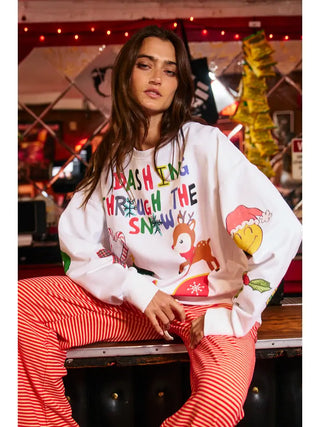 Person wearing a heather grey sweatshirt with colorful Christmas graphics, including reindeer and festive text.