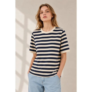 A woman wearing a navy and cream striped knit tee with a crew neckline and short sleeves.