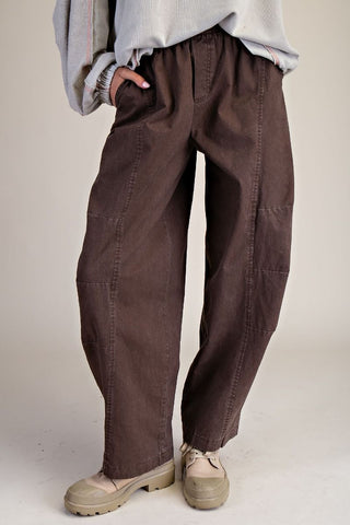 Brown loose fit barrel pants with an elastic waistband, worn with a light top.
