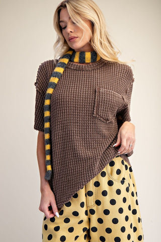 A brown washed waffle knit top with a relaxed fit, featuring short sleeves and a pocket.